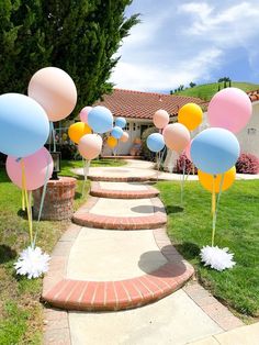 balloons and streamers are on the sidewalk in front of a house with steps leading up to it