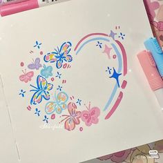 a drawing with butterflies and stars in the shape of a heart on top of paper