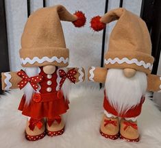 two stuffed gnomes dressed in red and white outfits, standing next to each other