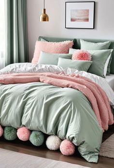 a bed with green sheets and pink pom poms