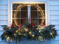 a window sill decorated with christmas lights and greenery