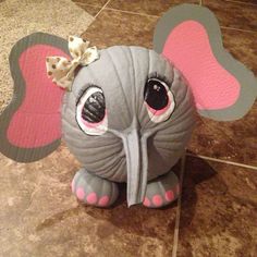 an elephant toy sitting on top of a tiled floor next to a tile floor with pink and gray hearts