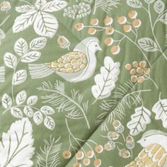 a green and white floral print fabric with birds, leaves and flowers on it's side