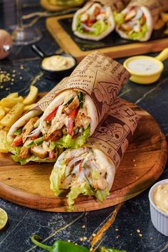 a sandwich cut in half sitting on top of a cutting board next to some fries