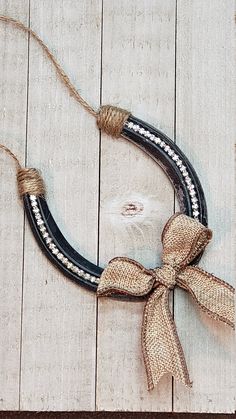 a rope wrapped around a black and white ring on top of a wooden floor next to a piece of string