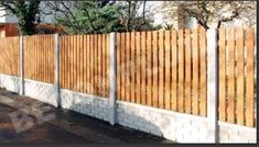 a wooden fence next to a white brick wall