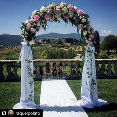 an outdoor wedding ceremony setup with flowers and greenery on the aisle, overlooking mountains