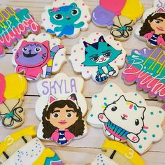 decorated cookies with cartoon characters on them sitting on a wooden table next to each other