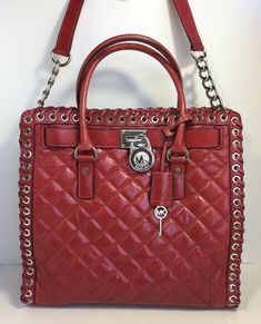 Michael Kors Hamilton large quilted tote in genuine leather Color red & silver tone hardware Chain link and leather shoulder strap with a 12.5" drop Michael Kors Hamilton Large Hippie Grommet North South Tote in Quilted Leather Michael Kors Browse Handbags  The tried-and-true Hamilton gets a slick update in soft quilted leather with grommeted edge. Accented by gleaming logo charms, the generous interior stows essentials with ease.  Michael Kors Double handles with 4.5"drop;   magnetic closure Ex Quilted Totes, North South, Tote Bag Purse, Michael Kors Hamilton, Quilted Leather, Large Fashion, Women's Bags, Magnetic Closure, Chain Link