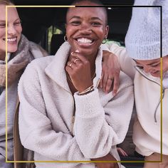 two women are smiling while sitting in the back of a car with their arms around each other