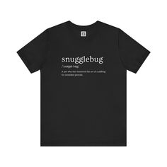 Embrace comfort and style with our Snugglebug T-Shirt. This classic black tee features a playful definition of 'snugglebug' in a stylish font, making it a perfect choice for pet lovers and cuddle enthusiasts alike. Crafted from soft, breathable fabric, it ensures all-day comfort while showcasing your love for those cozy moments.         Why You'll Love It: 👕 Ultimate Comfort: Made with 100% Airlume combed and ring-spun cotton, this tee offers a lightweight (4.2 oz/yd² or 142 g/m²) and breathabl Funny Black T-shirt With Name Print, Cozy Moments, Stylish Fonts, Meet Friends, Just Relax, Pet Lovers, Leisure Wear, Fashion Lover, Running Errands