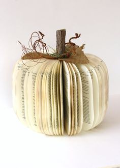 an open book in the shape of a pumpkin sitting on top of a white table