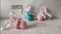 three crocheted baby booties with bows on them