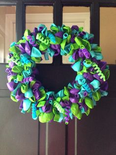 a purple and green wreath hanging on the front door