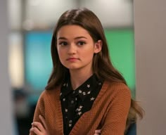 a young woman standing with her arms crossed