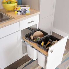 an open drawer in a kitchen next to a sink filled with food and other items