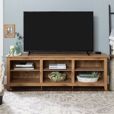 a flat screen tv sitting on top of a wooden entertainment center in a living room