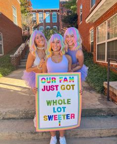 three girls holding a sign that says our fam just got a whole lot sweeter