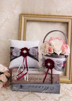 two flower baskets sitting on top of books next to a pillow and flowers in a basket