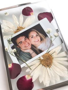 a photo frame with flowers and petals on it