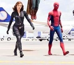 the spider - man and woman are walking towards an airplane on the tarmac with other people