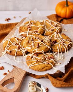 cookies with white icing and nuts on a cutting board