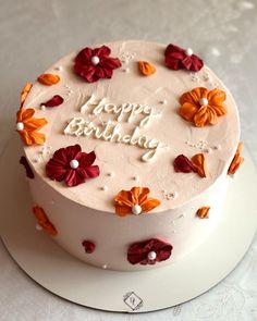 a white cake with red and orange flowers on it