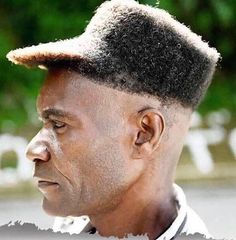 a close up of a person with a hat on his head and trees in the background