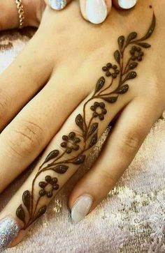 a woman's hand with a flower tattoo on it