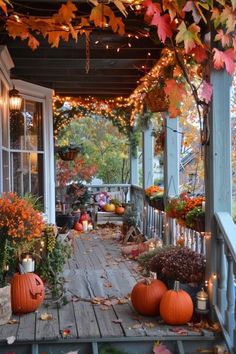 the porch is decorated with pumpkins and fall foliage