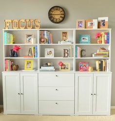 a white bookcase with lots of books on top of it and yellow circles in the middle