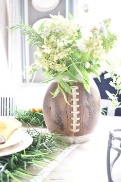 a vase filled with flowers on top of a table next to plates and utensils