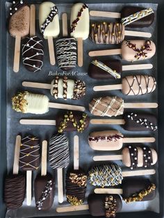 a tray filled with lots of different types of ice creams and chocolate covered pops