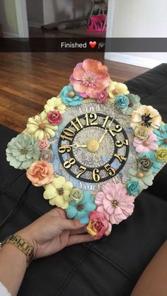 a person holding a clock with flowers on it