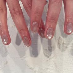 a woman's hand with white and silver nail polish on top of her nails