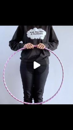 a woman holding a hula hoop in her hands and wearing a black shirt with the words don't me to a balloon on it