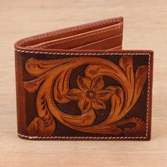 Replete with western flair, this wallet from India's Vikram Uberoi is a standout. Artisans tool the brown leather wallet by hand with leaf and flower motifs on the front and a woven motif on the back. Inside, a pocket for bills and six bank card slots help keep you organized. Rustic Brown Wallets With Card Slots, Artisan Brown Wallets With Coin Pocket, Brown Artisan Wallet With Coin Pocket, Rustic Brown Bifold Wallet, Brown Hand Tooled Trifold Wallet, Brown Embossed Leather Wallet, Brown Hand-tooled Wallets For Everyday Use, Brown Embossed Wallet For Everyday Use, Traditional Brown Leather Wallet