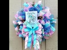 a blue and pink wreath with a sign on it