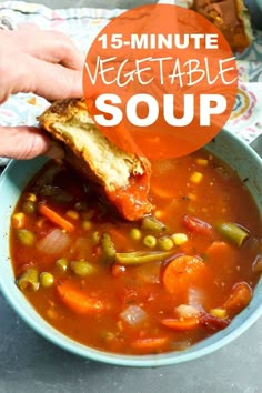 a person holding a piece of bread over a bowl of vegetable soup with the words, 15 - minute vegetable soup