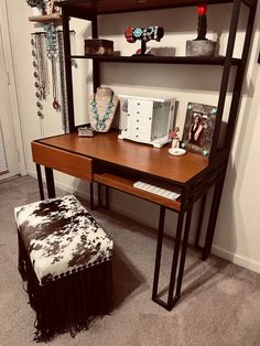 a wooden desk topped with a shelf filled with jewelry