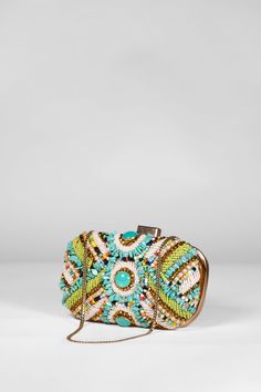 Colorful beaded clutch, highlighted by a striking turquoise bead. The clutch is secured with a clasp closure and offers versatility with a detachable gold shoulder strap for added convenience. Bohemian Beaded Evening Clutch, Bohemian Beaded Clutch, Bohemian Multicolor Clutch For Evening, Bohemian Multicolor Evening Clutch, Bohemian Beaded Gold Clutch, Bohemian Gold Beaded Clutch, Bohemian Summer Evening Clutch, Turquoise Rectangular Shoulder Bag For Evening, Turquoise Rectangular Evening Shoulder Bag