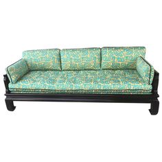 a green and blue couch sitting on top of a wooden frame