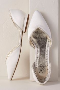 a pair of white shoes with pearls on them