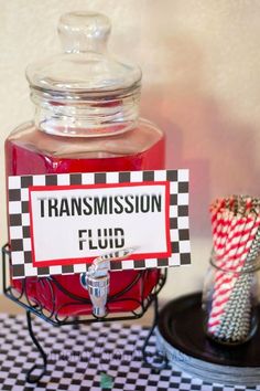 a glass jar filled with liquid sitting on top of a black and white checkered table cloth