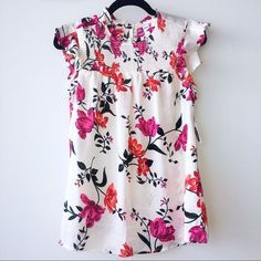 Gorgeous Spring/Summer Top From Old Navy. Features Ruffle-Sleeves, And Key-Hole Button At Back Of Neck. Classy, Cool, And Elegant. Size Medium, 100% Polyester. Floral Pattern. New With Tags. Have You Checked Out Our Other Fabulous Items? Are You Bundling Your Likes For The Best Deal? Did You Know Bundling Also Saves Shipping Fees? Only Want This Item? We Also Love Offers! White Ruffle Sleeve Blouse For Summer, White Ruffle Sleeve Tops For Vacation, White Floral Print Blouse With Flutter Sleeves, White Blouse With Floral Print And Ruffle Sleeves, White Floral Print Flutter Sleeve Blouse, Pink Floral Print Button-up Shirt, Pink Floral Print Button-up Blouse, Tiered Blouse, Classic Capsule Wardrobe