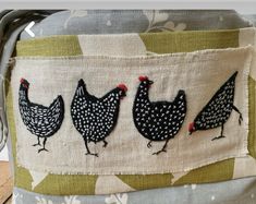 three chickens are on the side of a fabric covered bucket with handles and straps,