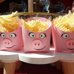 three pink bags filled with fries sitting on top of a table