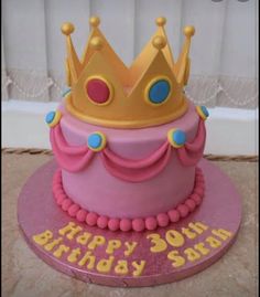 a pink birthday cake with a gold crown on top that says happy 30th birthday son