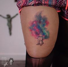 a woman's thigh with a colorful tattoo on her leg and an image of a teddy bear