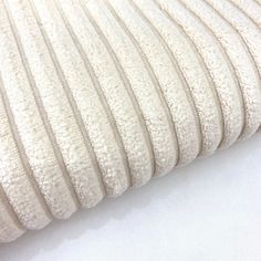 a close up view of a white fabric textured with thin lines on a plain surface